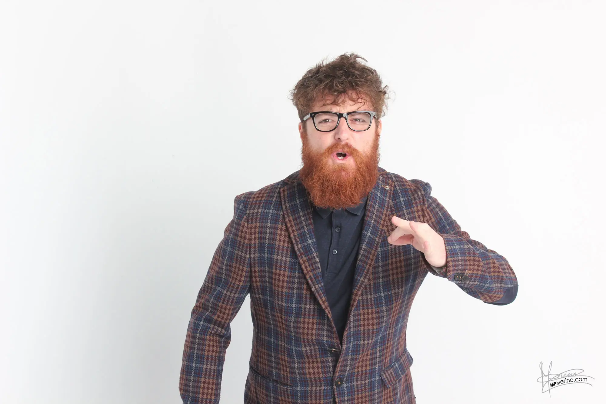 Studio photograph of a gesticulating comedian angry at the camera