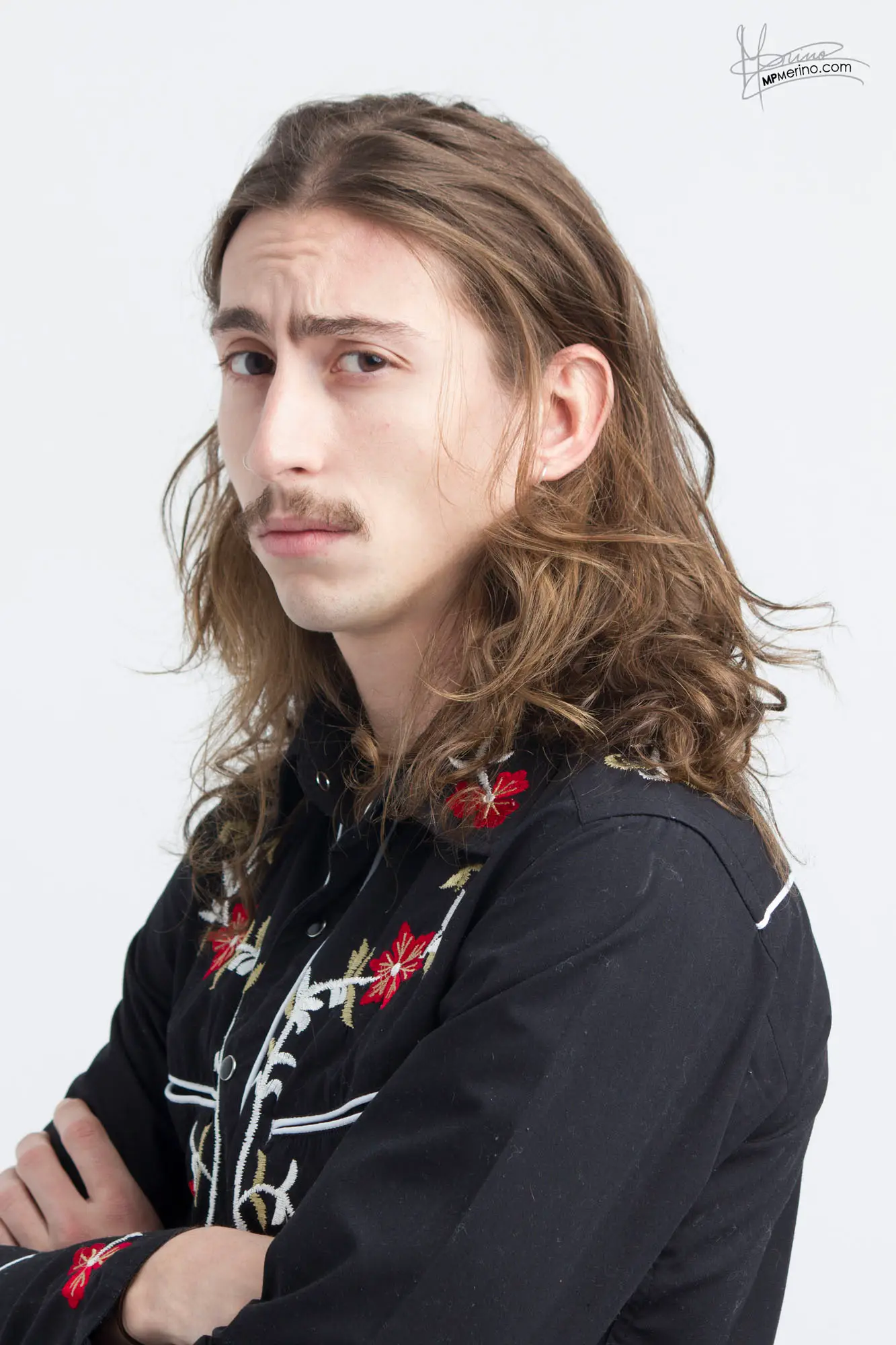 Studio portrait of a long-haired boy looking at the camera