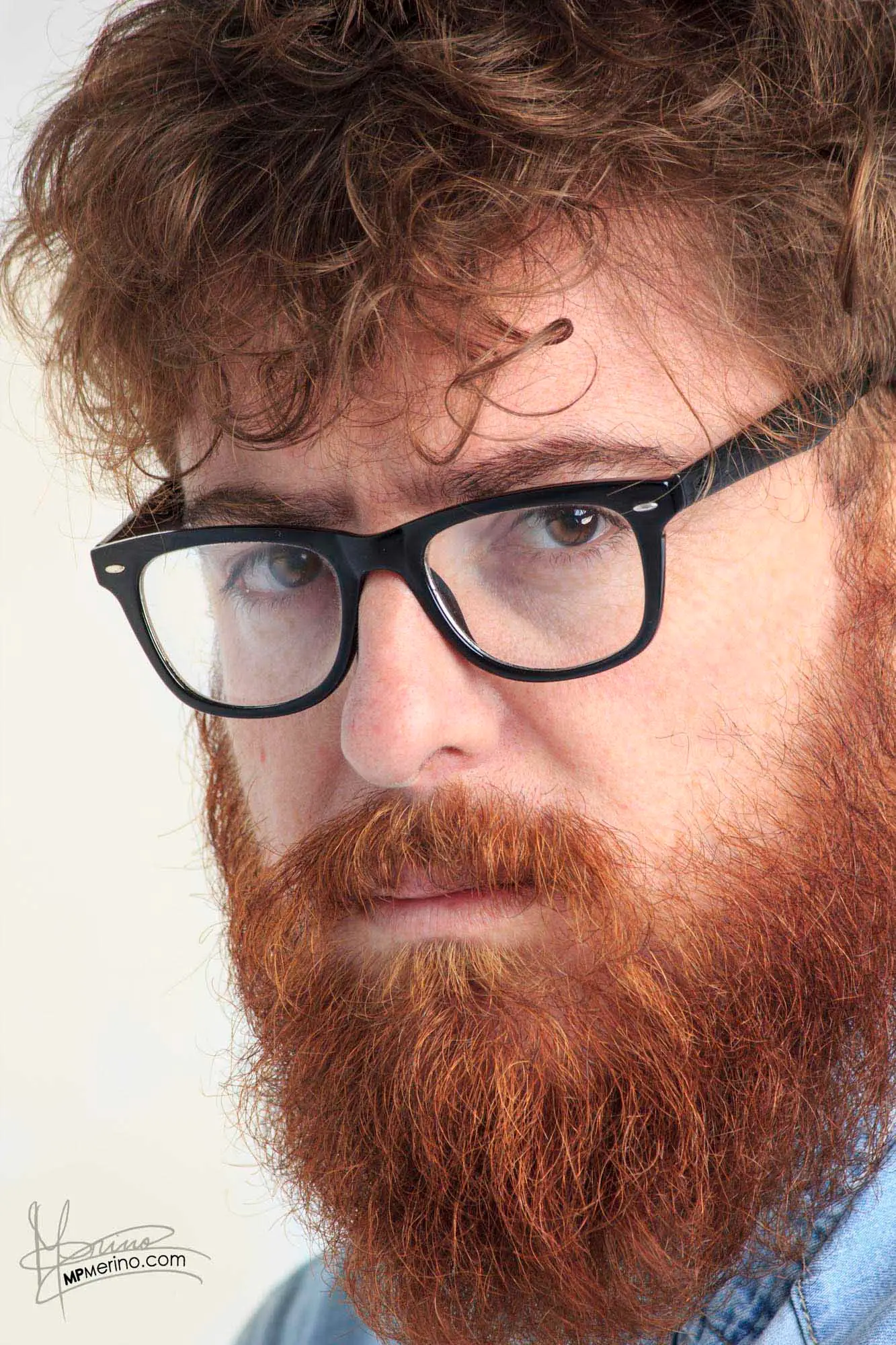 Close-up of a red-haired man looking very serious at the camera