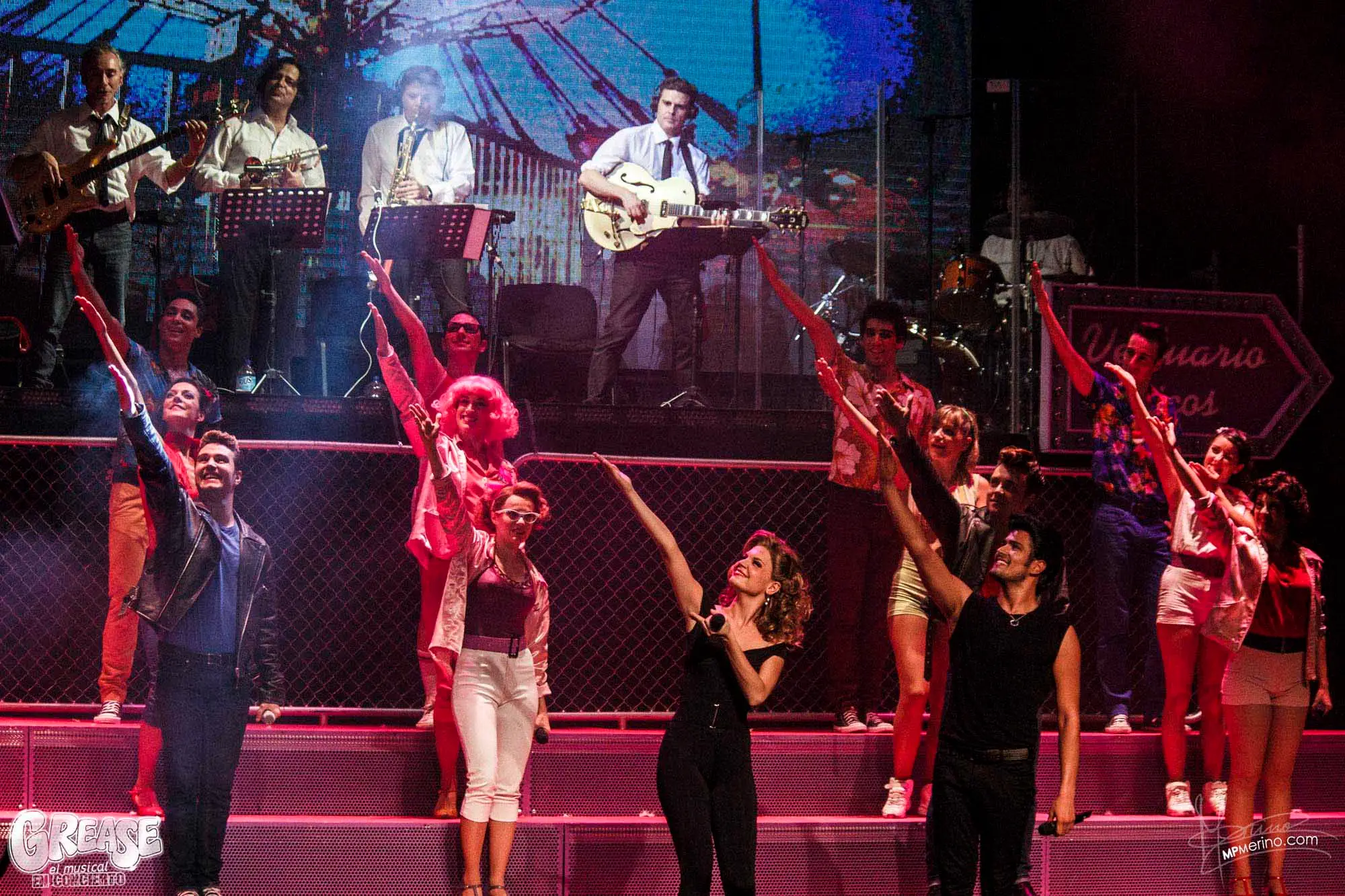 Musical theatre photograph, the cast of Grease pointing to smiling crew members