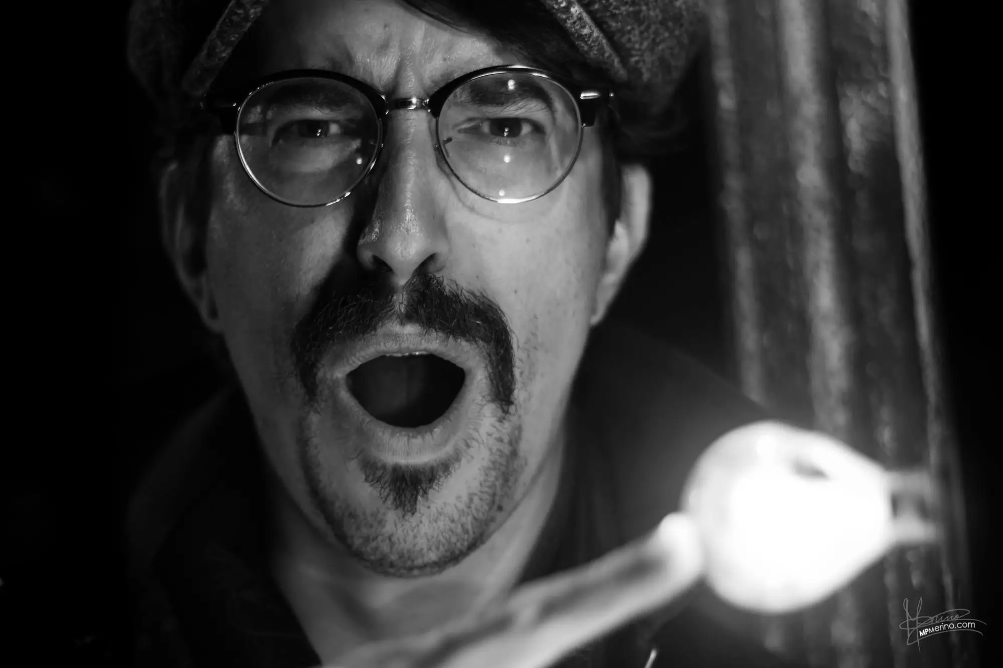 Portrait of an actor touching a light bulb and looking angry