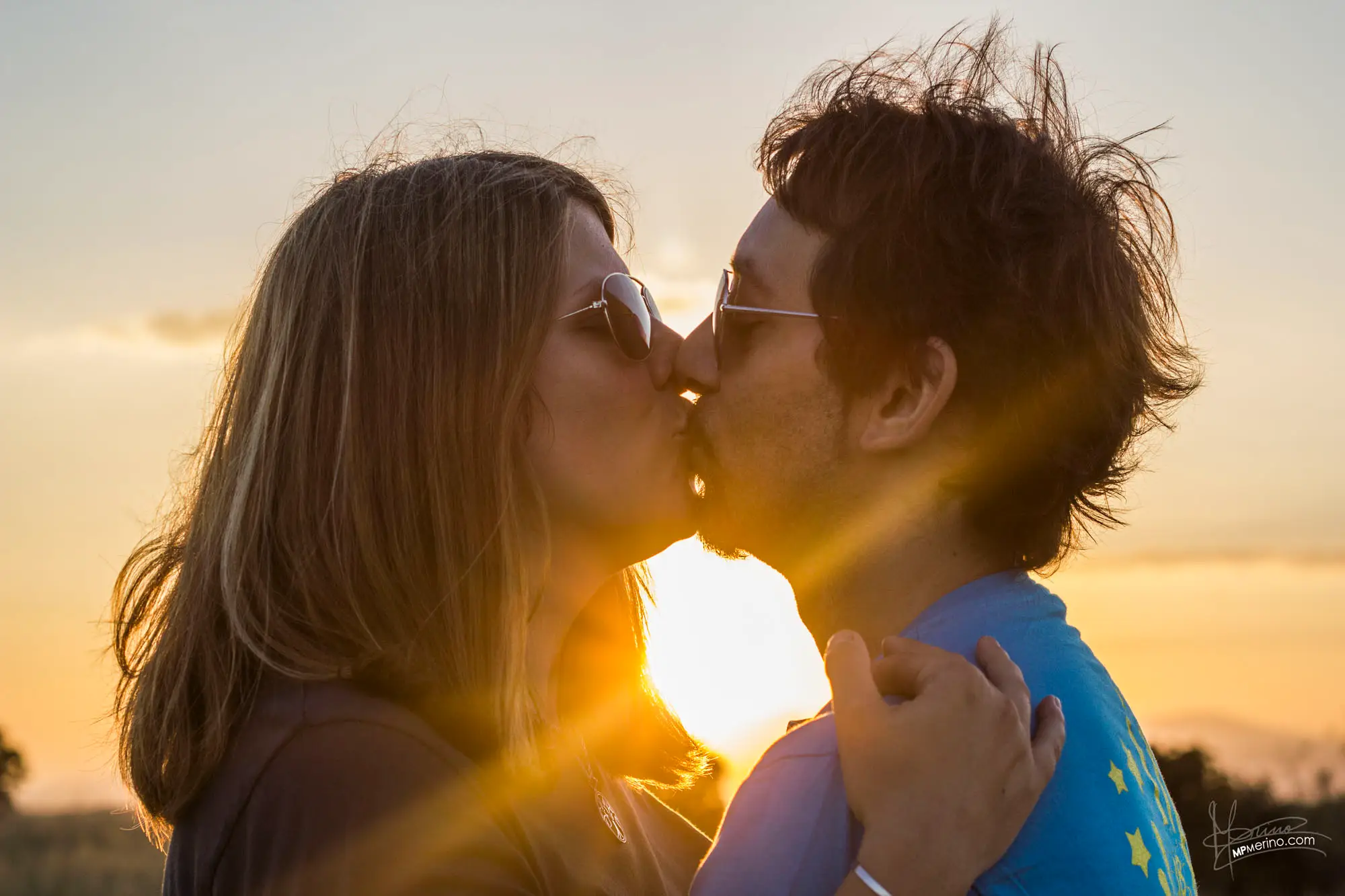 Portrait of a kissing couple with the sun against the light