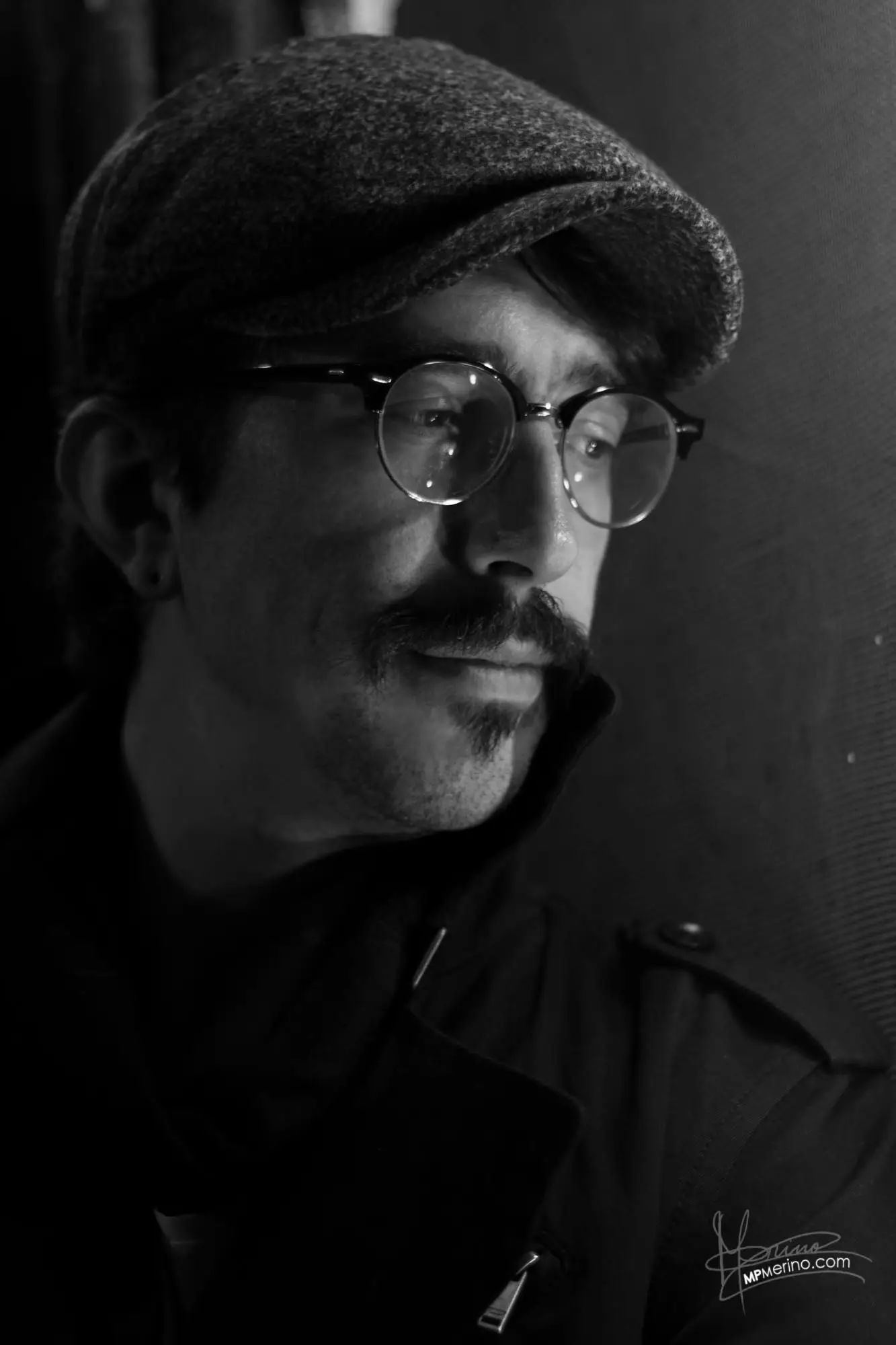Portrait of a boy with a beret and glasses looking down